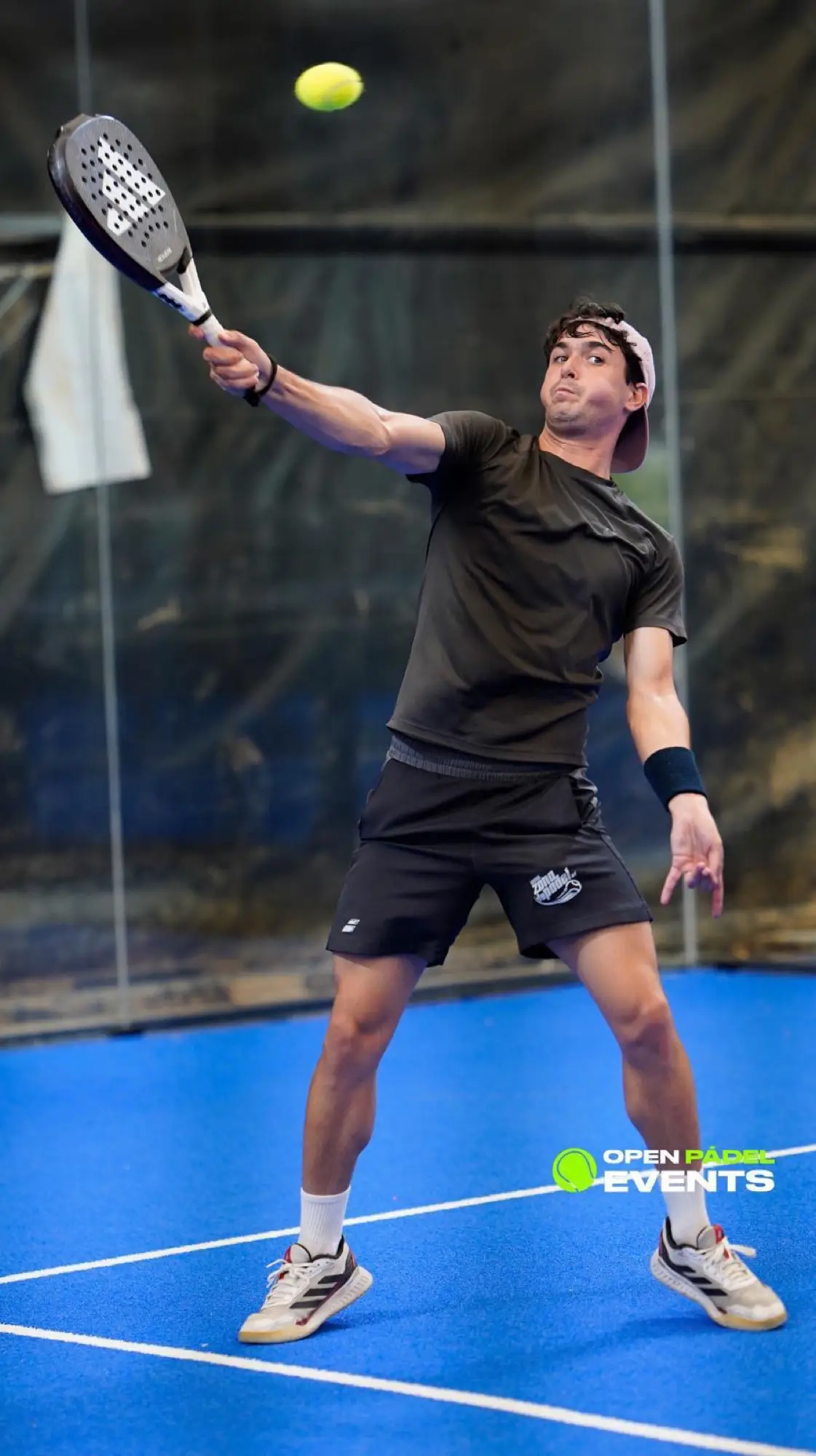 Player reaching for an overhead in a padel rally