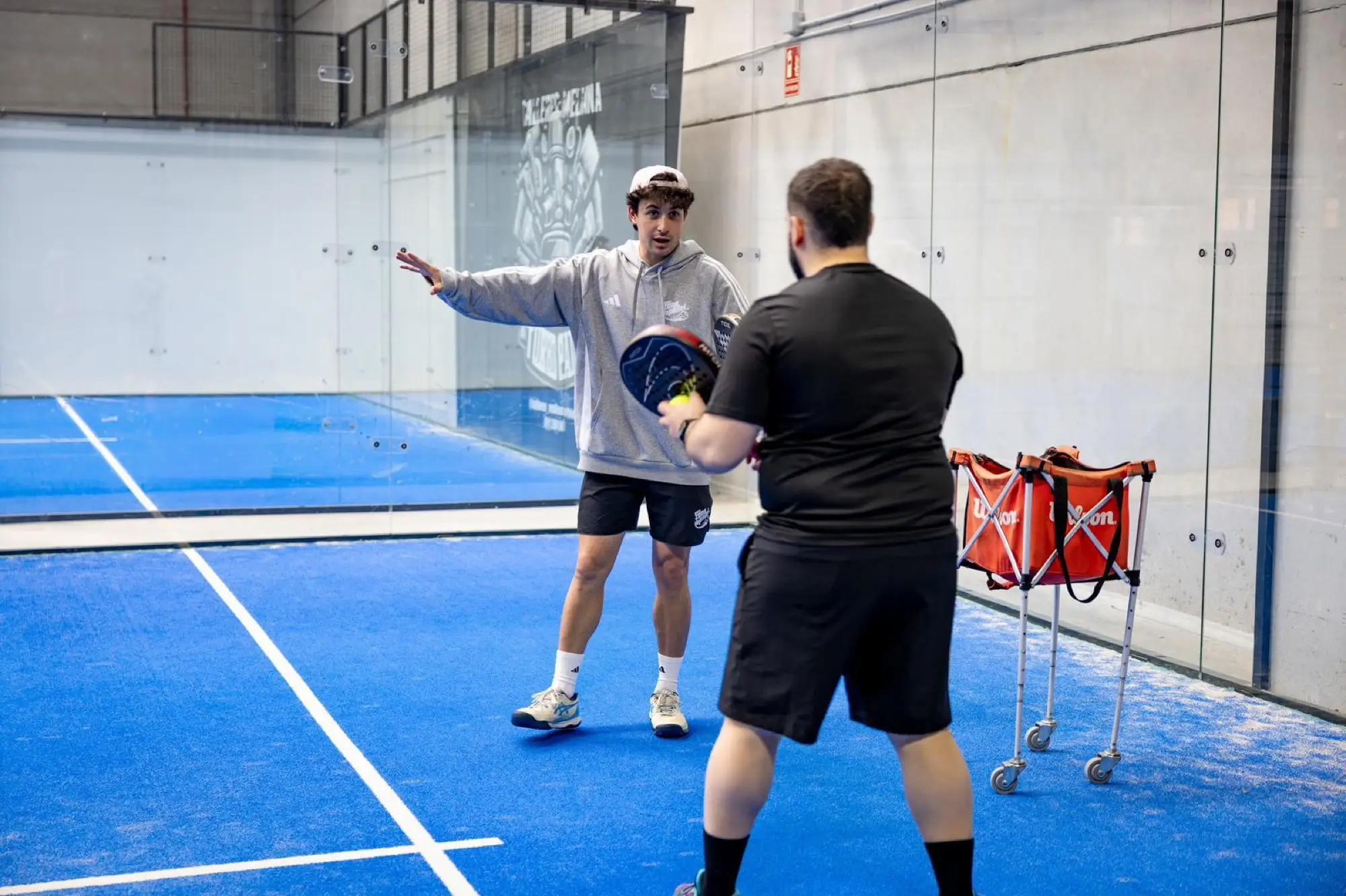 Coach feeding balls during a padel drill
